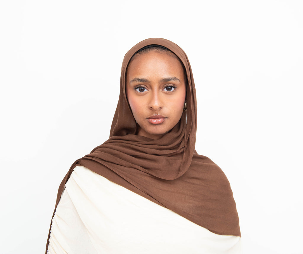 Chocolate brown modal hijab with matching undercap - soft lightweight fabric
Woman wearing chocolate brown hijab - elegant modest fashion
Chocolate brown modal scarf 180x100cm - breathable high-quality hijab
Close-up chocolate brown modal hijab fabric drape - luxurious texture
Chocolate brown hijab and jersey undercap set - everyday modest wear