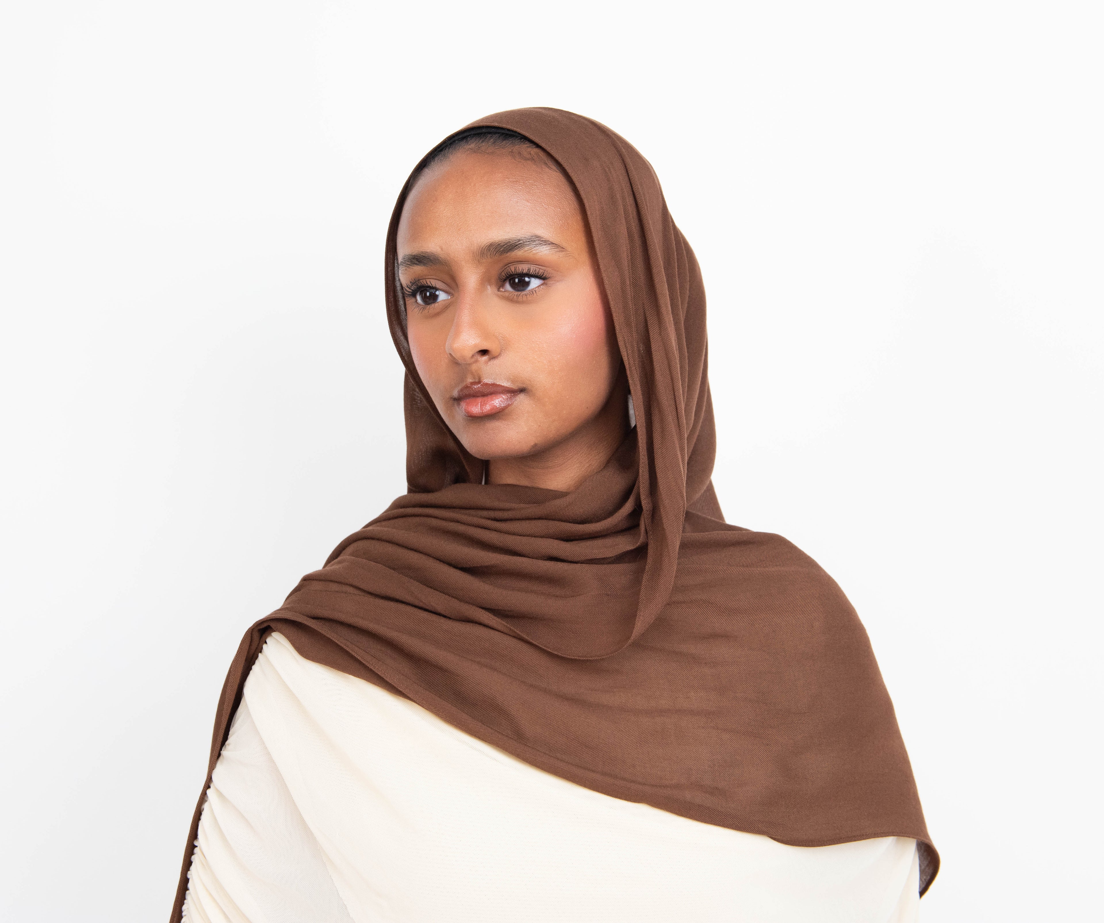 Chocolate brown modal hijab with matching undercap - soft lightweight fabric
Woman wearing chocolate brown hijab - elegant modest fashion
Chocolate brown modal scarf 180x100cm - breathable high-quality hijab
Close-up chocolate brown modal hijab fabric drape - luxurious texture
Chocolate brown hijab and jersey undercap set - everyday modest wear