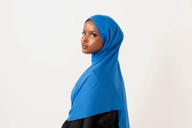 Royal blue modal hijab with matching jersey undercap - soft lightweight 100% modal fabric UK
Woman wearing royal blue hijab draped elegantly - modest fashion style UK
Royal blue modal scarf 180x100cm - breathable high-quality hijab with undercap
Close-up royal blue modal hijab fabric texture - luxurious soft drape
Royal blue hijab set - modal scarf and matching cotton jersey undercap UK